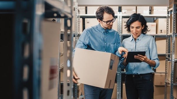 Female Inventory Manager Shows Digital Tablet Information to a W